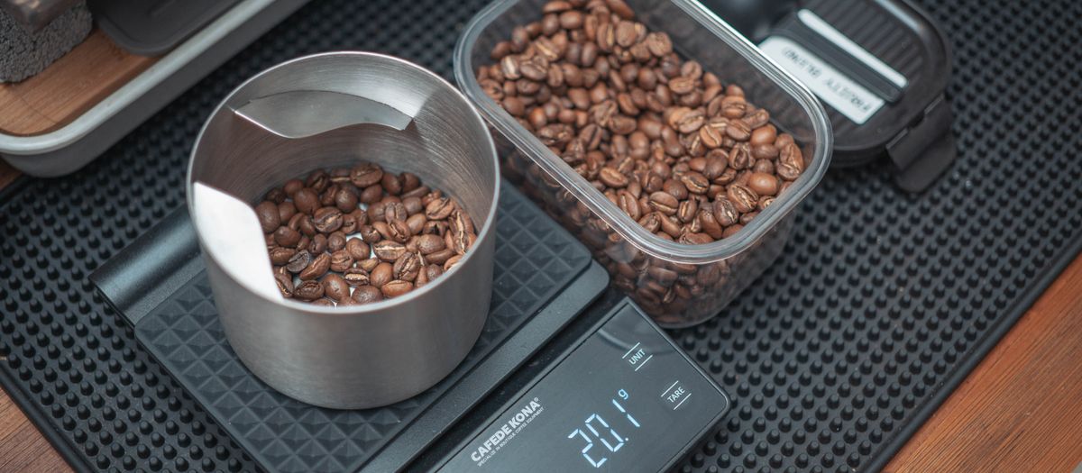 An espresso shot pouring into a cup on a scale.